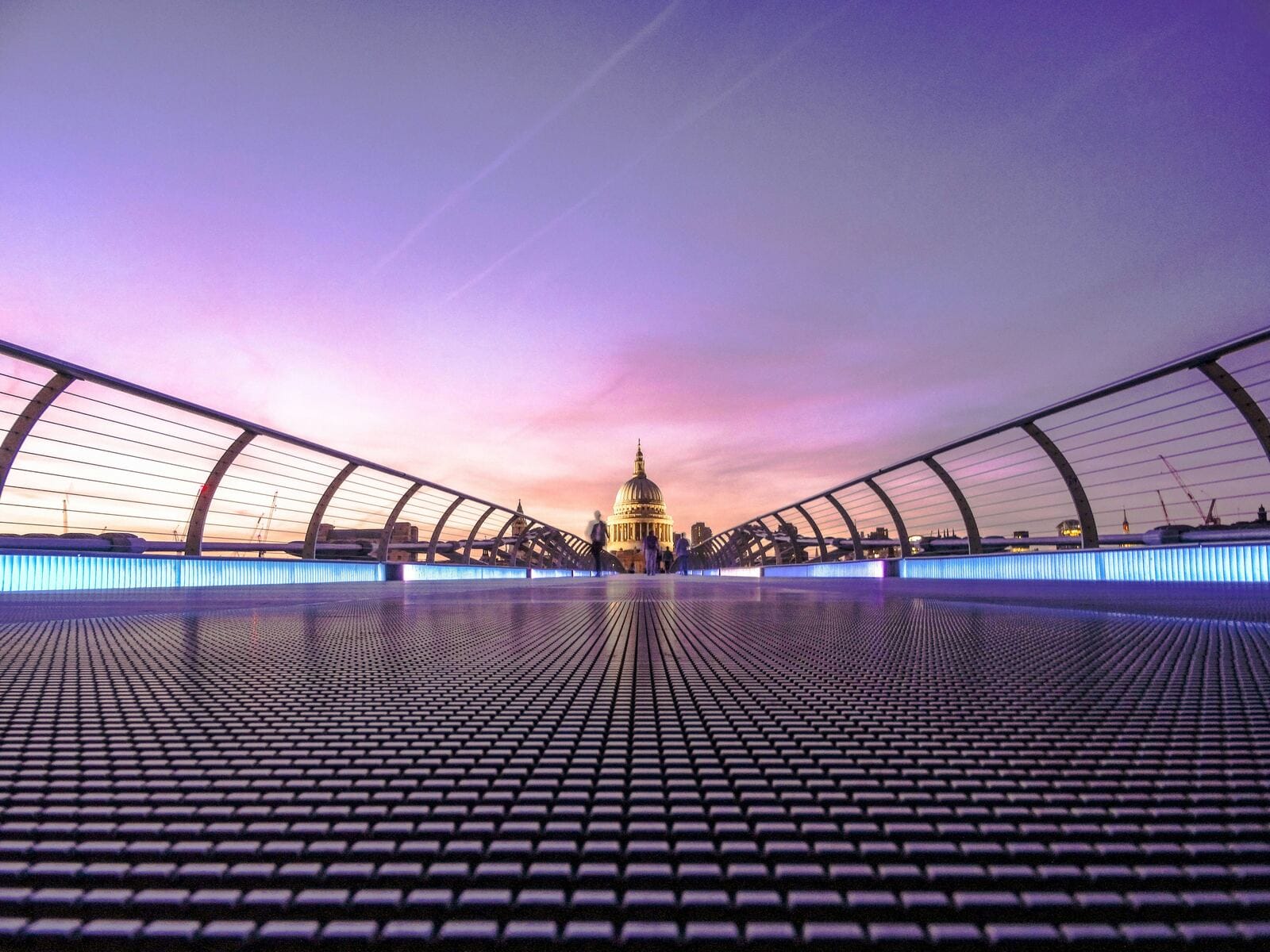 A pedestrian bridge leading toward a historic dome at sunset, symbolizing the long path from a simple net-30 catalog to a full credit-building platform