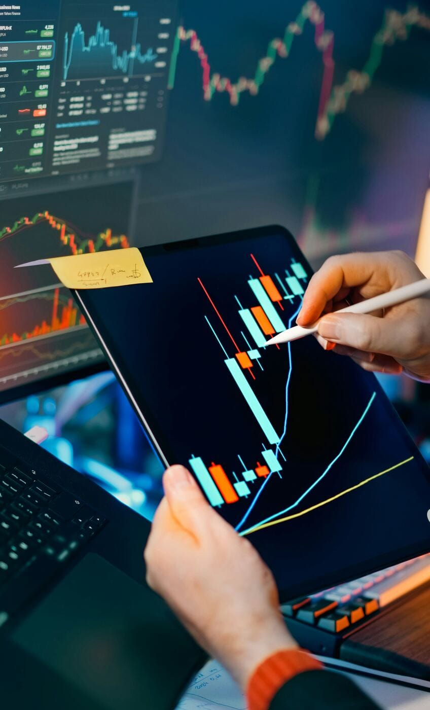 A hand annotating a financial chart on a tablet with a stylus, representing tracking your progress after watching the walkthrough